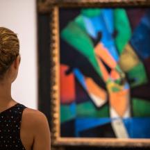 a woman looking at a painting in a mirror