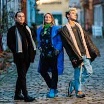 a group of three people walking down a street