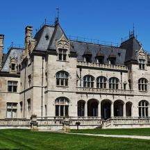 a large stone building with a green lawn in front