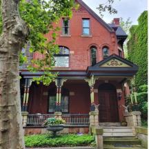 a red brick house with a tree in front of it