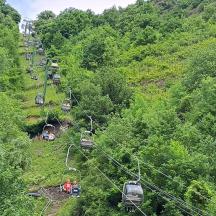 eine Gruppe von Menschen auf einem Skilift in einem Wald