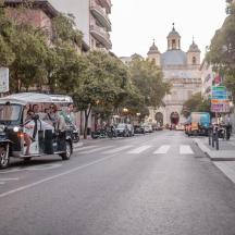 an old car driving down a city street