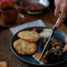 a person with a knife and fork and a plate of food