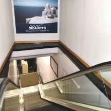 eine Rolltreppe in einem Gebäude mit einem Schild an der Wand