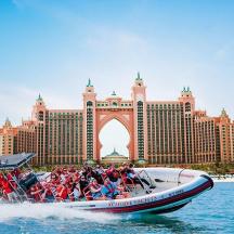 a group of people on a boat in the water in front of a resort