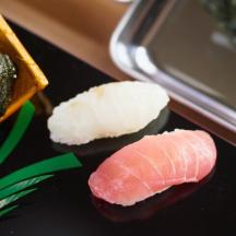 tre typer sushi på et bord med en telefon