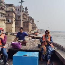 three people sitting on a boat in the water