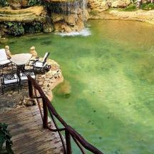 eine Terrasse mit Tisch und Stühlen in einem Teich