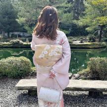 eine Frau im Kimono steht vor einem Teich