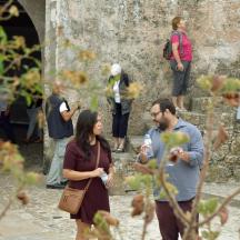 a man and a woman standing next to a stone wall