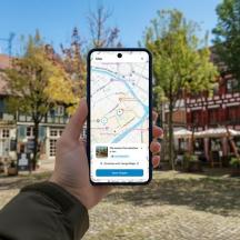 una persona que sosté un telèfon mòbil amb un mapa