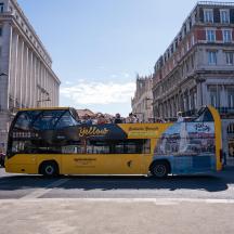 a yellow double decker bus driving down a street