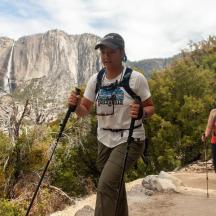 two people walking on a trail in a canyon