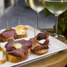 a plate of pastries and two glasses of wine