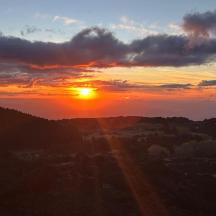 en solnedgang med solen der går ned over en by