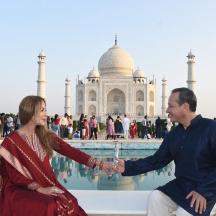 a couple holding hands in front of the taj mahal