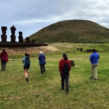 a group of people walking around a hill