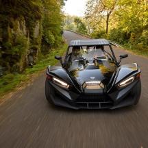 a black car is driving down a road