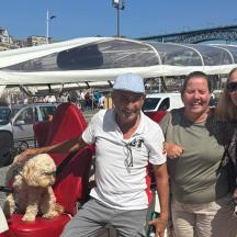 two women and a man with a dog in a golf cart
