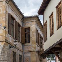 un vecchio edificio con persiane in legno su una strada