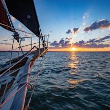 a boat in the ocean with a sunset in the background