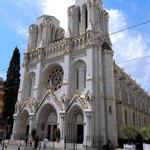 a large white church with people walking in front of it