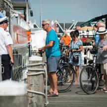 a group of people standing on a dock with bikes