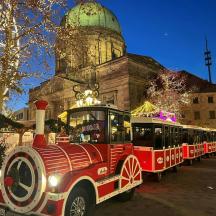 Un tren rojo en exhibición frente a un edificio.