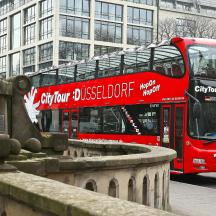 a red double decker bus driving down a street