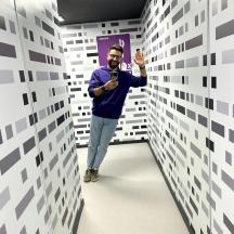 a man taking a picture in a room with white walls
