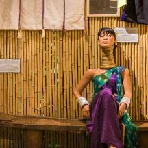 a woman in a dress is sitting on a shelf