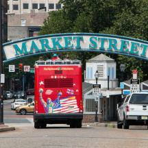 a red truck driving down a street under a market street sign