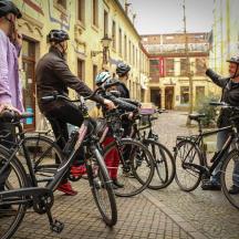 a group of people standing with bikes on a street