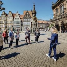 eine Gruppe von Menschen steht auf einer Straße in einer Stadt