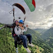 dua orang menaiki parasut di langit