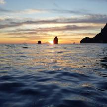 ein Sonnenuntergang über dem Meer mit Felsen im Wasser