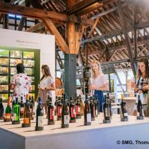 un gruppo di donne in piedi attorno a una mostra di bottiglie di vino
