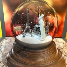 une femme debout dans une boule à neige avec la tour Eiffel