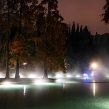a fountain with lights in a park at night