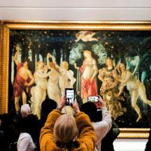 people taking pictures of a painting in a museum