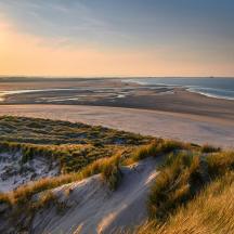 an aerial view of a beach at sunset