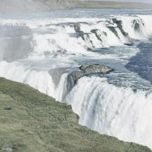 a waterfall on the side of a river