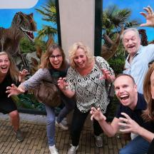 sekumpulan orang bergambar di hadapan lukisan dinosaur