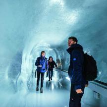 eine Gruppe von Menschen, die durch eine Eishöhle gehen