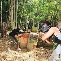 two people standing in a forest with barrels