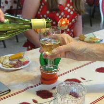 a person pouring a glass of wine on a table