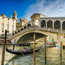 isang gondola sa isang kanal sa harap ng isang tulay