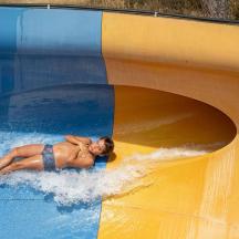 a man is laying on a water slide