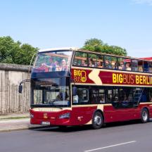 a red double decker bus driving down a street