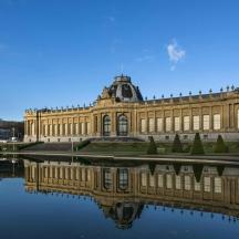 a large building with its reflection in the water